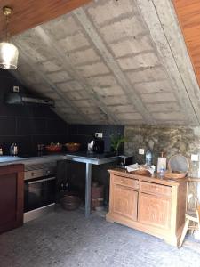 a kitchen with black walls and a wooden ceiling at A Casa Estrelícia-Dourada Garcês in São Vicente