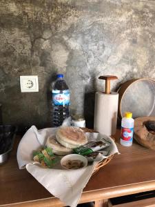 een tafel met een bord eten en een fles water bij A Casa Estrelícia-Dourada Garcês in São Vicente