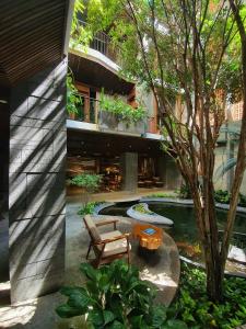 a building with a pool and a bench and a tree at Minh Boutique in Danang