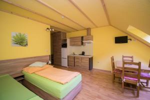 a room with a bed and a table and a kitchen at Penzion Sidorovo in Ružomberok