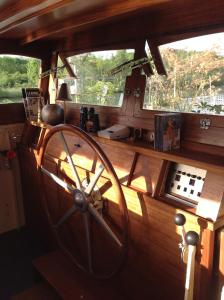 a large wooden wheel in a room with two windows at Bateau, Péniche Marboré - Disney in Lagny