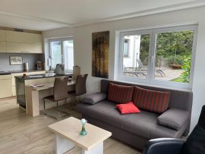 ein Wohnzimmer mit einem Sofa und einer Küche in der Unterkunft Maly´s Ferienwohnung in Sulzberg