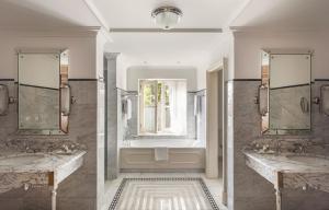 two sinks in a bathroom with two mirrors at Reid's Palace, A Belmond Hotel, Madeira in Funchal