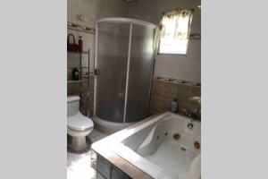 ein Bad mit einer Badewanne und einem WC in der Unterkunft My dulce hogar in Isabela