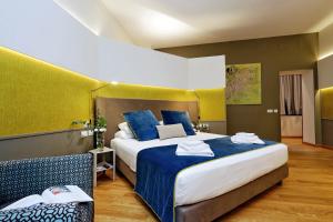 een hotelkamer met een groot bed met blauwe lakens bij Relais Vittoria Colonna in Rome