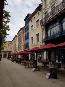 a street with tables and chairs and umbrellas at Maison vue Cité 2 in Carcassonne