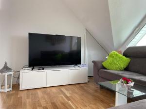 a living room with a large television on a white cabinet at Sunshine in Messen