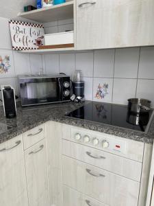 a kitchen with a stove and a microwave at Sunshine in Messen +8 photos
