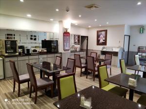 a restaurant with tables and chairs and a kitchen at Blue Sky Motel in Guishan