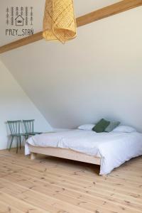 a bedroom with a bed and a wooden floor at PRZY_STAŃ in Czapelsko