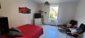 een slaapkamer met een rood bed en stoelen en een raam bij Appartement avec jardin à Colmar in Colmar