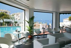 ein Wohnzimmer mit einem Pool, Tischen und Stühlen in der Unterkunft Luxury apartment- magnificent view in Pego