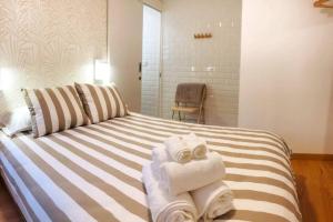 Una habitación con una cama con toallas. en El Escondite de la Muralla en Cáceres