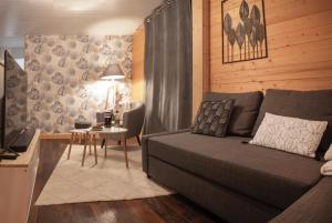 a living room with a couch and a table at Appartement Vue Lac in Malbuisson