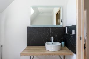 La salle de bains est pourvue d'un lavabo et d'un miroir. dans l'établissement Keroc'h - Maison vue mer & Jacuzzi, à Pleubian
