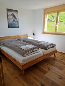 a large bed in a room with a window at Alpen-Park 2. Stock Ost in Riederalp