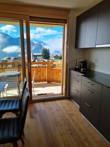 a kitchen with a large sliding glass door with a view at Alpen-Park 2. Stock Ost in Riederalp