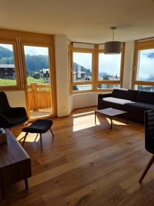 a living room with a couch and some windows at Alpen-Park 2. Stock Ost in Riederalp