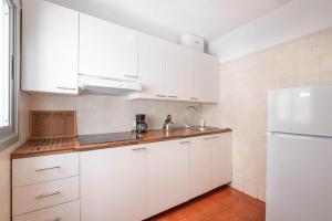 una cucina con mobili bianchi e un frigorifero bianco di Bubu Beach 3 a Los Cristianos
