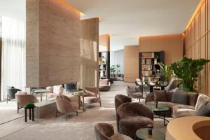 a lobby with couches and tables and chairs at Pan Pacific London in London