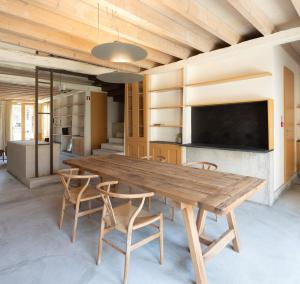 a dining room with a wooden table and chairs at Na Travessa Suítes in Porto