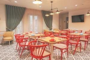 a dining room with wooden tables and red chairs at Mouraria Lisboa Hotel in Lisbon