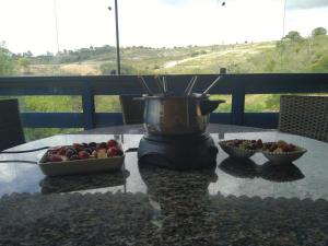 a blender on a table with two bowls of fruit at Casa Cantinho da Paz, seu lazer completo, churrasqueira, piscina e muita tranquilidade in Gravatá