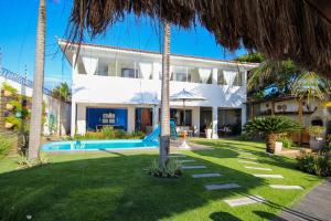 a villa with a swimming pool and a resort at Casa pé na areia na Praia de Genipabu by Carpediem in Extremóz