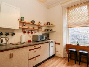 a kitchen with a microwave and a stove and a window at Struan House in Aberfeldy