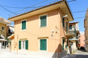 a building with green shutters on a street at Kiko Studios I in Corfu Town