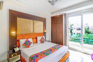 sypialnia z dużym łóżkiem i dużym oknem w obiekcie FabHotel Kiara The Private Suites w mieście Gurgaon