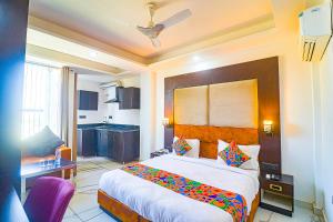 sypialnia z łóżkiem i biurkiem oraz kuchnia w obiekcie FabHotel Kiara The Private Suites w mieście Gurgaon