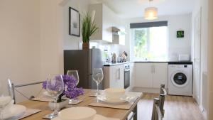 een keuken en eetkamer met een tafel met wijnglazen bij Unique & Exclusive Contractor and Family House & A1 Road in Grantham