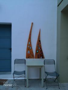 two chairs sitting next to a table in a room at Domatia me Thea in Elafonisos