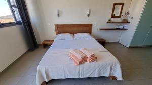a bedroom with a bed with two towels on it at Domatia me Thea in Elafonisos