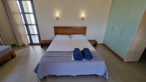 a bedroom with a bed with blue shoes on it at Domatia me Thea in Elafonisos