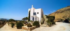 a white church with a cross on top of it at Domatia me Thea in Elafonisos