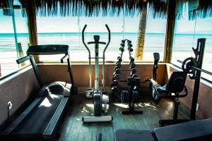 a gym with cardio equipment in front of the ocean at Cahy Praia Hotel in Prado