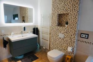 ein Badezimmer mit einem Waschbecken, einem WC und einem Spiegel in der Unterkunft FeWo26 in Thale