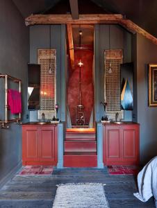 a bathroom with two sinks and a red door at Maison Fred Luxury Suites in Bruges