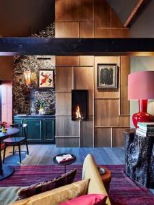 a living room with a fireplace and a couch at Maison Fred Luxury Suites in Bruges