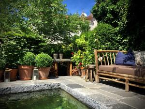 una panchina seduta accanto a una piscina d'acqua di Maison Fred Luxury Suites a Bruges