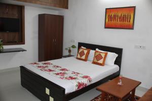een slaapkamer met een bed, een tafel en een tv bij Friendlystay - An Home Stay And Elite in Chennai