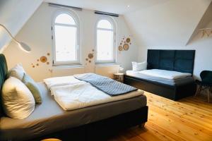 a bedroom with two beds and two windows at FeWo26 in Thale