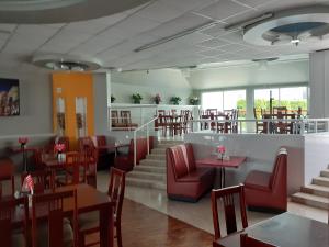 un restaurante con sillas rojas, mesas, mesas y sillas en Leo Hotel en Jerez de García Salinas
