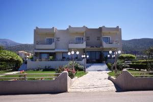 a large white building with flowers in front of it at Altis Hotel in Malia