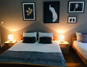 um quarto com uma cama com dois candeeiros e um gato na parede em Hotel Corner em Saraievo