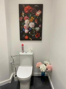 uma casa de banho com um WC branco e uma pintura na parede em The Pink Studio - Exceptional location IN city center - Unique & Elegant em Namur