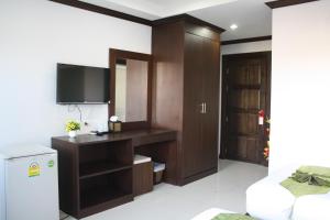 una pequeña sala de estar con TV y nevera. en Fruit Paradise Hotel, en Patong Beach