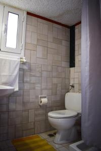 uma casa de banho com um WC, um lavatório e uma janela em Altis Hotel em Malia